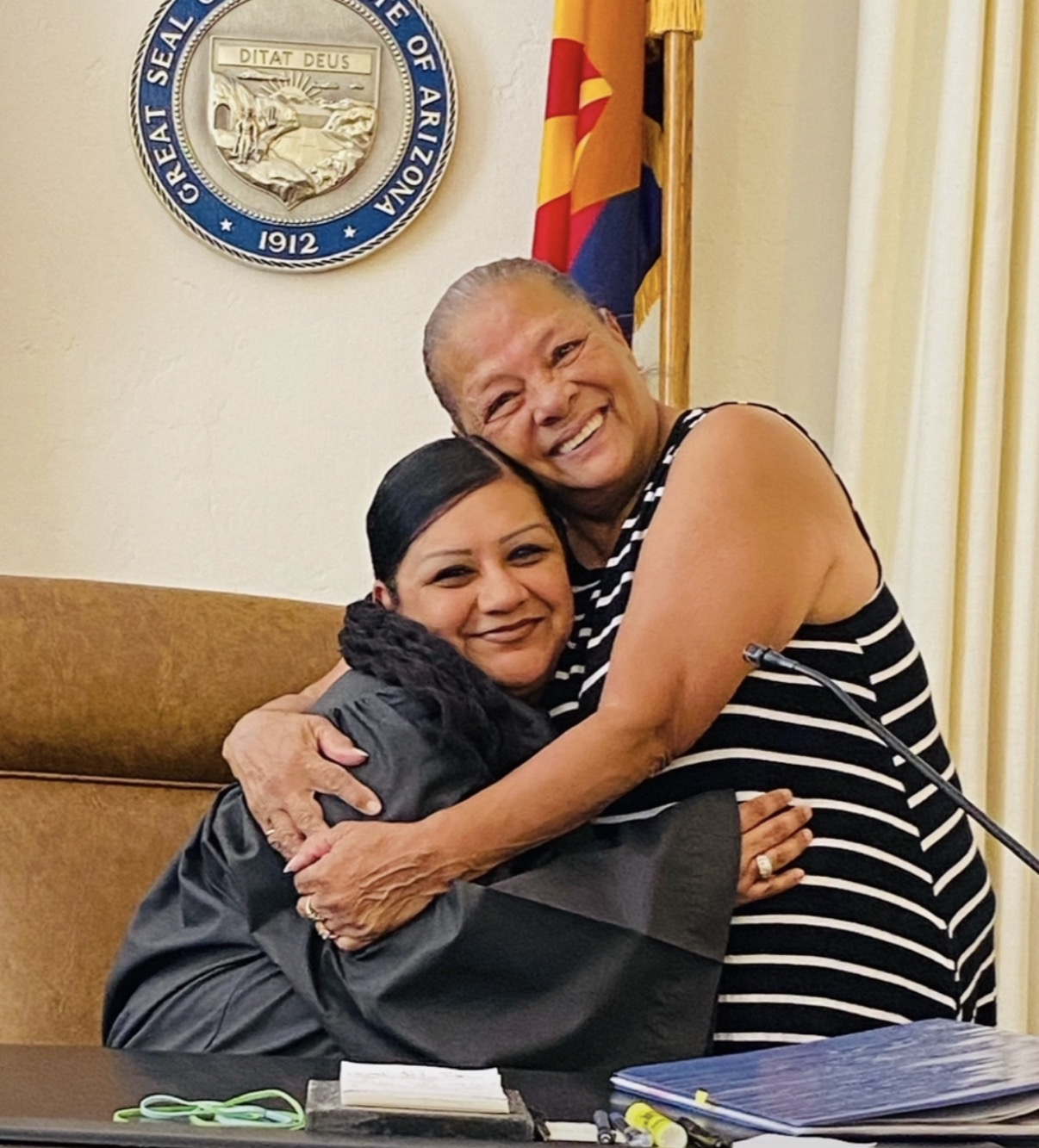 Juanita Escalante celebrating with a community member in a courtroom
